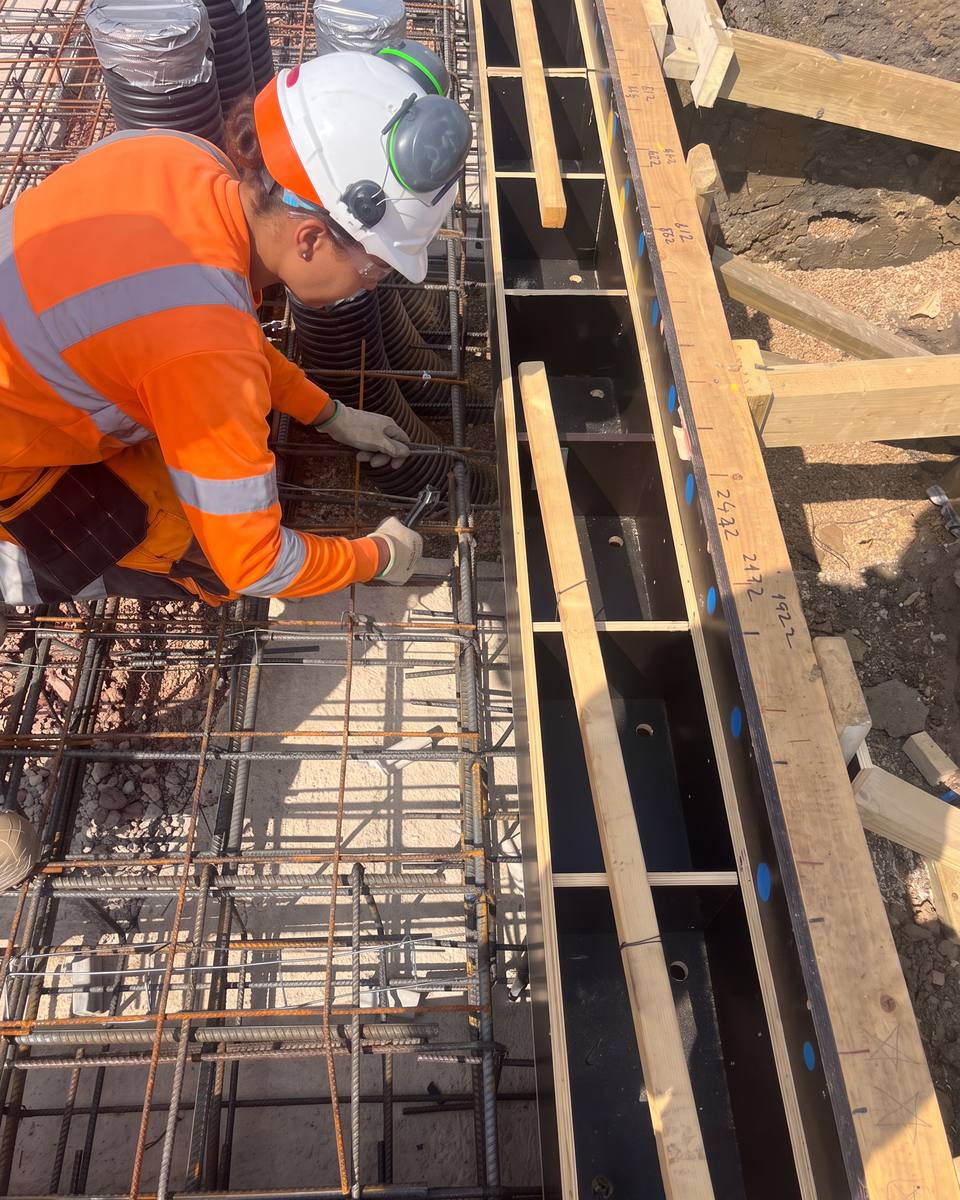 Steel fixer tying reinforcement at timber formwork