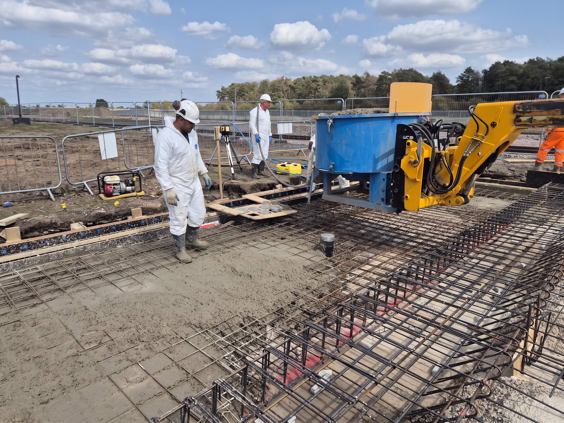 Telehandler skip discharging concrete onto a reinforced slab